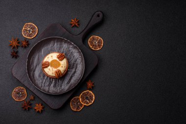 Beyaz narenciye kremalı ve fındıklı, koyu beton kaplamalı tatlı turta.