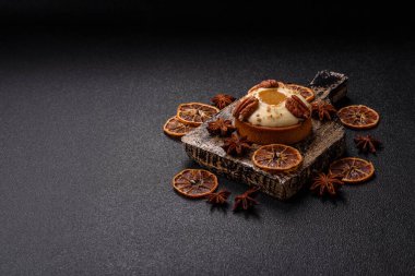 Beyaz narenciye kremalı ve fındıklı, koyu beton kaplamalı tatlı turta.