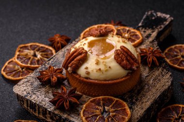 Beyaz narenciye kremalı ve fındıklı, koyu beton kaplamalı tatlı turta.