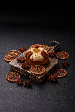 Beyaz narenciye kremalı ve fındıklı, koyu beton kaplamalı tatlı turta.