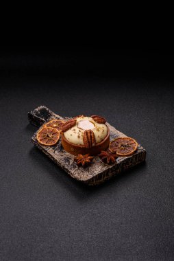 Beyaz narenciye kremalı ve fındıklı, koyu beton kaplamalı tatlı turta.