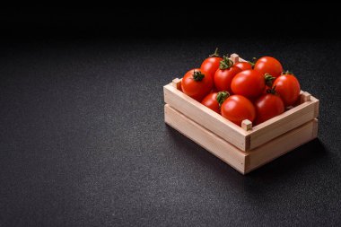 Koyu beton arka planda, tahta bir kutuda olgun kırmızı domatesler.