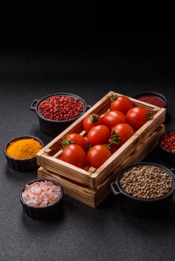 Koyu beton arka planda, tahta bir kutuda olgun kırmızı domatesler.