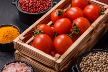 Koyu beton arka planda, tahta bir kutuda olgun kırmızı domatesler.