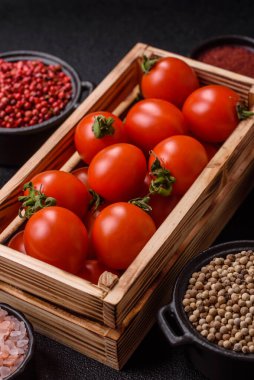 Koyu beton arka planda, tahta bir kutuda olgun kırmızı domatesler.