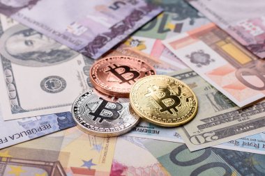 Farklı para birimlerinin kağıt banknotlarının arka planında yuvarlak metal bitcoin. Tasarımınız için arkaplan