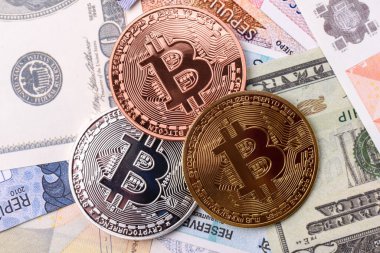 Farklı para birimlerinin kağıt banknotlarının arka planında yuvarlak metal bitcoin. Tasarımınız için arkaplan