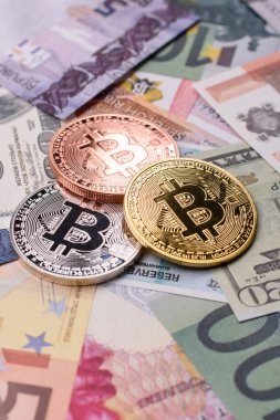 Farklı para birimlerinin kağıt banknotlarının arka planında yuvarlak metal bitcoin. Tasarımınız için arkaplan