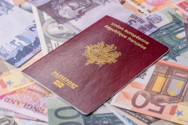Fransız vatandaşının uluslararası pasaportu farklı ülkelerin kağıt banknotlarının arka planında