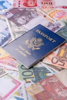 ABD vatandaşının uluslararası pasaportu, farklı ülkelerin kağıt banknotlarının arka planına karşıdır.