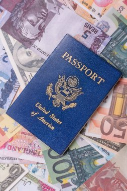 ABD vatandaşının uluslararası pasaportu, farklı ülkelerin kağıt banknotlarının arka planına karşıdır.