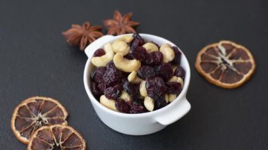 Koyu beton arka planda kavrulmuş kaju ve kurutulmuş kızılcık karışımı.