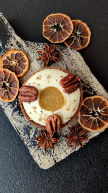 Beyaz narenciye kremalı ve fındıklı, koyu beton kaplamalı tatlı turta.