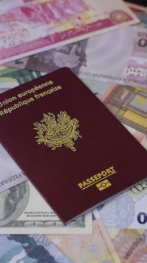 Fransız vatandaşının uluslararası pasaportu farklı ülkelerin kağıt banknotlarının arka planında