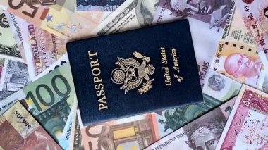 ABD vatandaşının uluslararası pasaportu, farklı ülkelerin kağıt banknotlarının arka planına karşıdır.