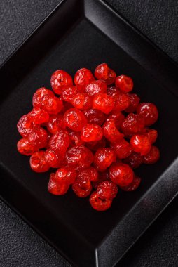 Kurumuş kırmızı kiraz veya koyu beton arka planda şekerli meyveler.