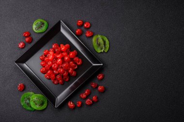 Kurumuş kırmızı kiraz veya koyu beton arka planda şekerli meyveler.