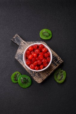 Kurumuş kırmızı kiraz veya koyu beton arka planda şekerli meyveler.