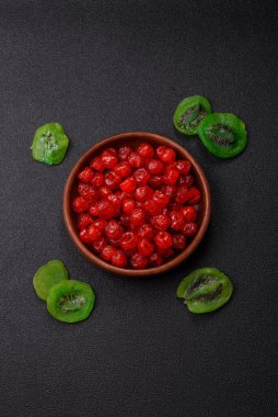 Kurumuş kırmızı kiraz veya koyu beton arka planda şekerli meyveler.