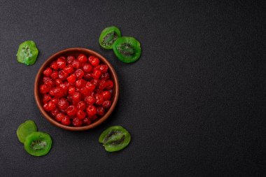 Kurumuş kırmızı kiraz veya koyu beton arka planda şekerli meyveler.