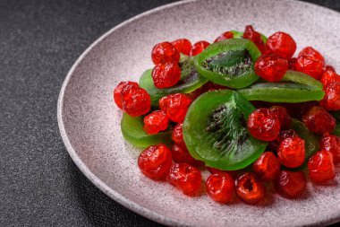 Kurumuş kırmızı kiraz veya koyu beton arka planda şekerli meyveler.