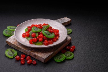 Kurumuş kırmızı kiraz veya koyu beton arka planda şekerli meyveler.