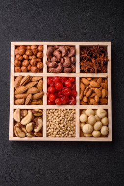 Ahşap bir kutunun içinde macadamia, çam, kaju, fındık, fıstık ve fıstık karışımı.