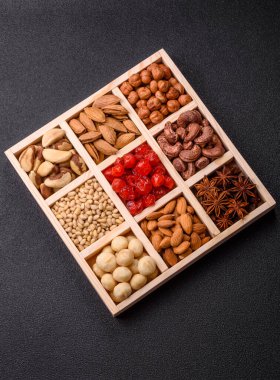 Ahşap bir kutunun içinde macadamia, çam, kaju, fındık, fıstık ve fıstık karışımı.