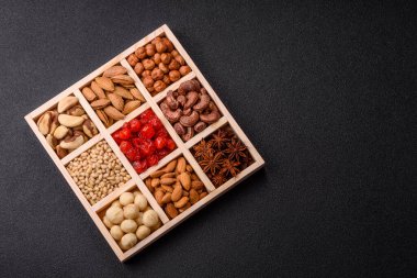 Ahşap bir kutunun içinde macadamia, çam, kaju, fındık, fıstık ve fıstık karışımı.