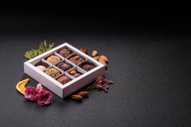 Koyu beton arka planda farklı dolgu ve serpiştirilmiş ev yapımı çikolatalı şekerler.