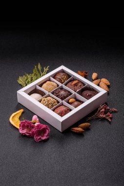 Koyu beton arka planda farklı dolgu ve serpiştirilmiş ev yapımı çikolatalı şekerler.