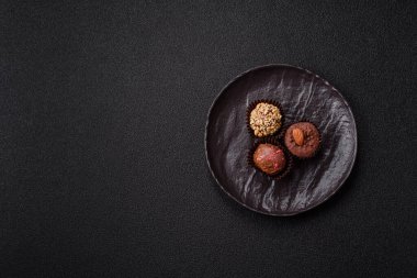 Koyu beton arka planda farklı dolgu ve serpiştirilmiş ev yapımı çikolatalı şekerler.