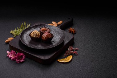 Koyu beton arka planda farklı dolgu ve serpiştirilmiş ev yapımı çikolatalı şekerler.