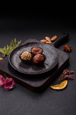 Koyu beton arka planda farklı dolgu ve serpiştirilmiş ev yapımı çikolatalı şekerler.