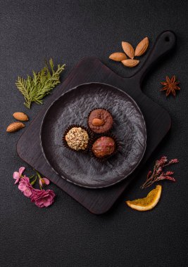 Koyu beton arka planda farklı dolgu ve serpiştirilmiş ev yapımı çikolatalı şekerler.