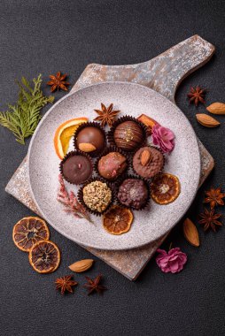 Koyu beton arka planda farklı dolgu ve serpiştirilmiş ev yapımı çikolatalı şekerler.