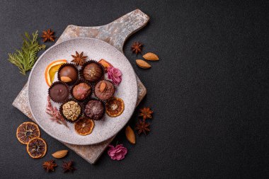 Koyu beton arka planda farklı dolgu ve serpiştirilmiş ev yapımı çikolatalı şekerler.