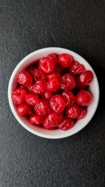 Kurumuş kırmızı kiraz veya koyu beton arka planda şekerli meyveler.