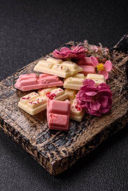 Çok renkli çikolatalar pembe, beyaz, kahverengi, koyu beton arka plan