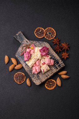 Çok renkli çikolatalar pembe, beyaz, kahverengi, koyu beton arka plan