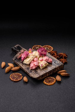 Çok renkli çikolatalar pembe, beyaz, kahverengi, koyu beton arka plan