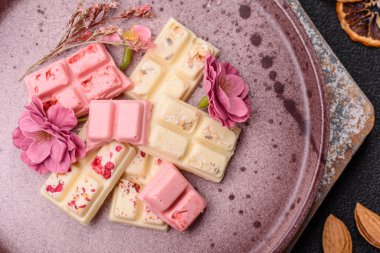 Çok renkli çikolatalar pembe, beyaz, kahverengi, koyu beton arka plan