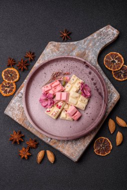 Çok renkli çikolatalar pembe, beyaz, kahverengi, koyu beton arka plan