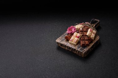 Çok renkli çikolatalar pembe, beyaz, kahverengi, koyu beton arka plan