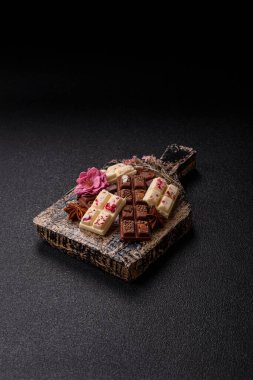 Çok renkli çikolatalar pembe, beyaz, kahverengi, koyu beton arka plan