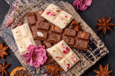 Çok renkli çikolatalar pembe, beyaz, kahverengi, koyu beton arka plan