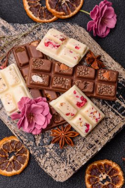 Çok renkli çikolatalar pembe, beyaz, kahverengi, koyu beton arka plan