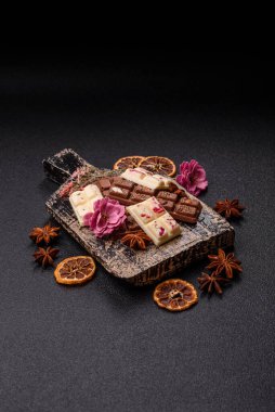 Çok renkli çikolatalar pembe, beyaz, kahverengi, koyu beton arka plan