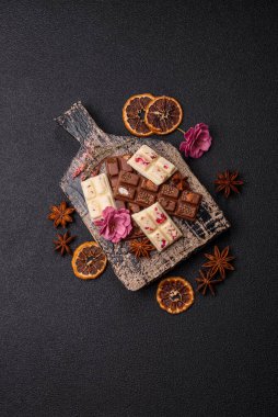 Çok renkli çikolatalar pembe, beyaz, kahverengi, koyu beton arka plan