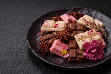 Çok renkli çikolatalar pembe, beyaz, kahverengi, koyu beton arka plan